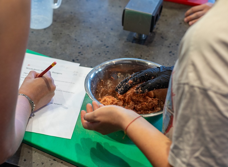 handen van jongeren met scorelijst en schaal met voeding