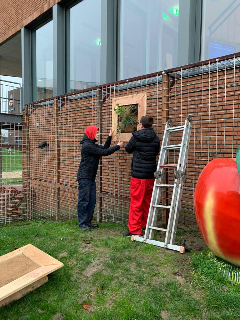 leerling en docent bij groene gevel