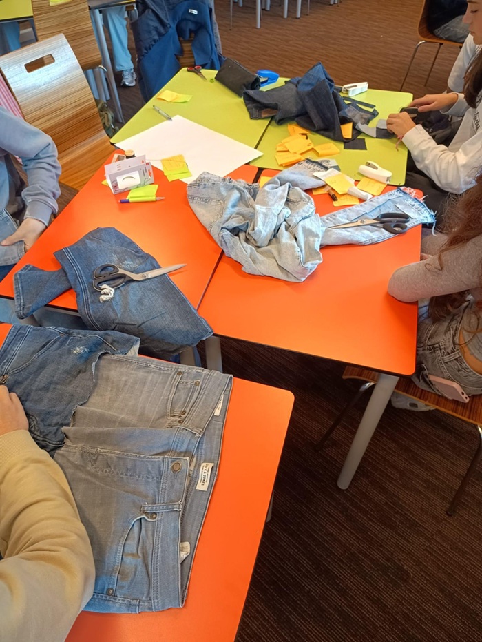 leerlingen knippen spijkerkleding om iets nieuws te maken