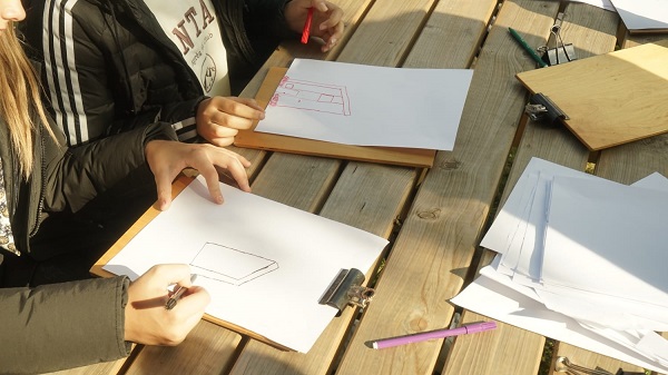 leerlingen werken op buitentafel