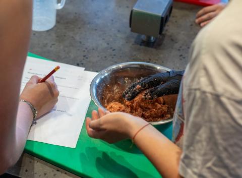 handen van jongeren met scorelijst en schaal met voeding