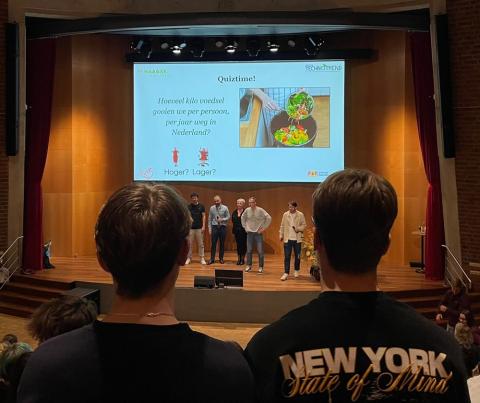 podium met quizvraag op groot scherm 